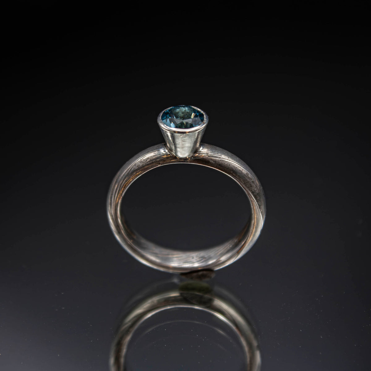shibuichi mokume ring with blue topaz.